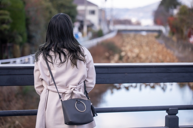 橋の上で遠くを見つめる女性